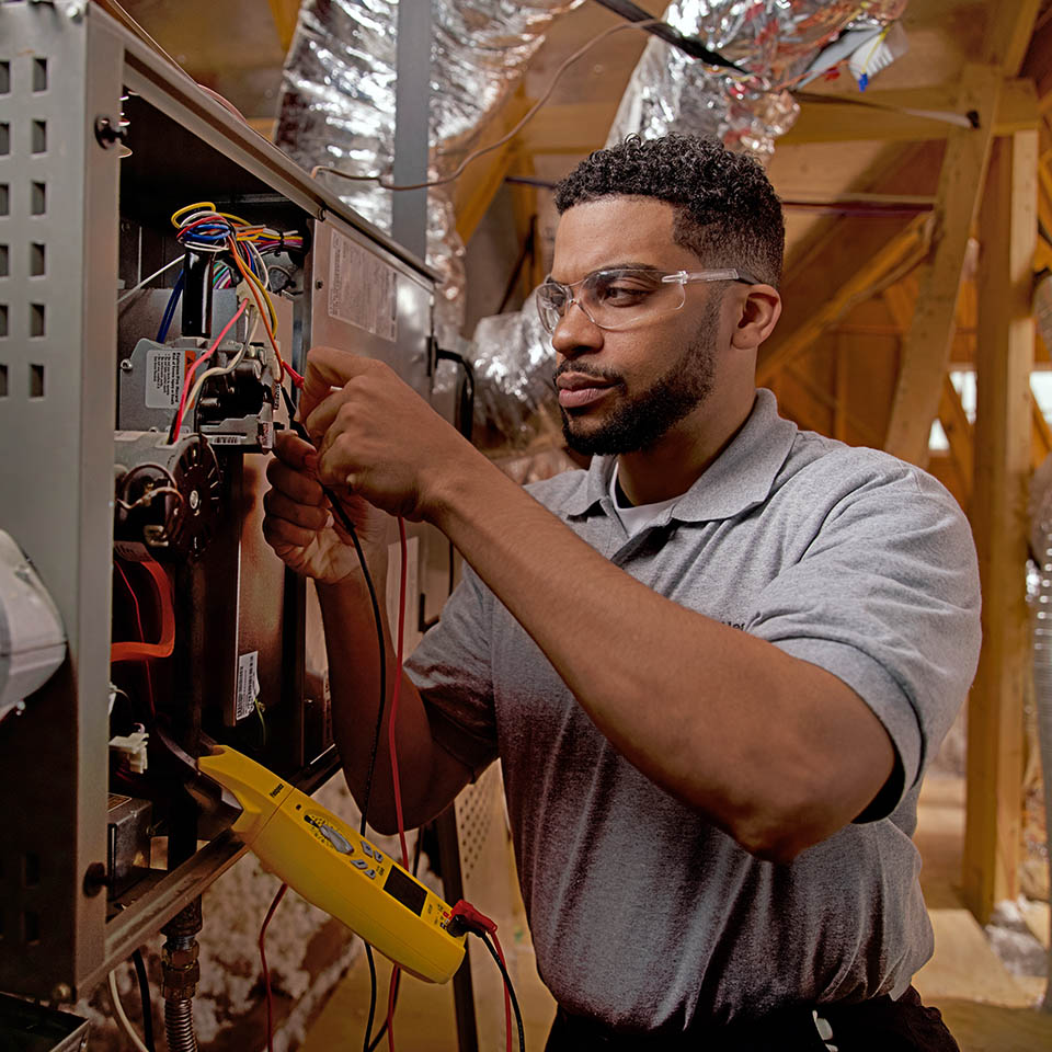 HVAC technician working on a furnace system.